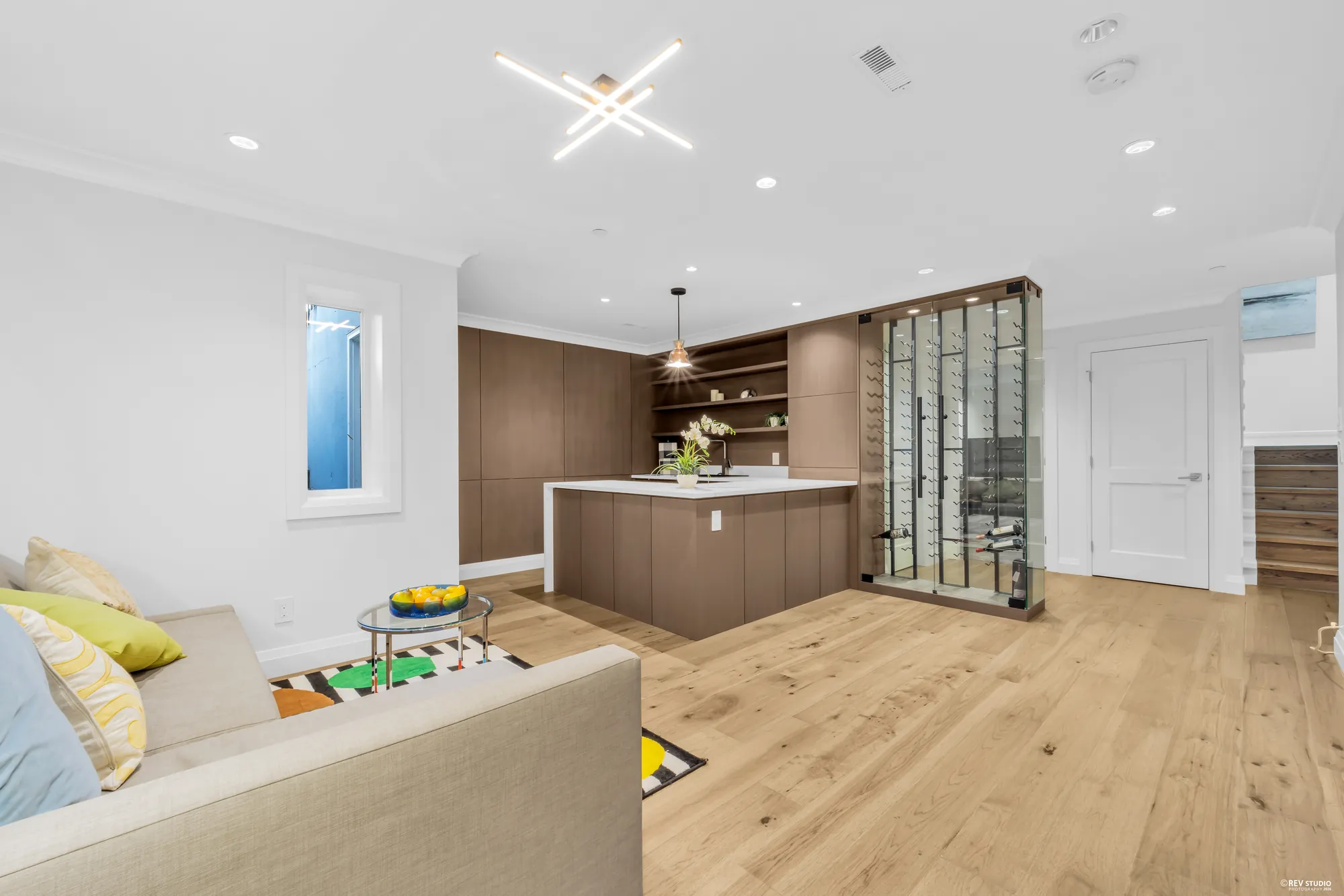The wet bar with a stone counter, shelving above and the wine store to the right