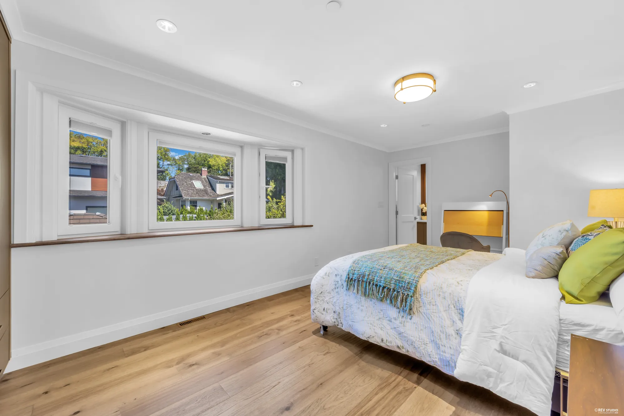The same bedroom looking along the window wall toward the desk