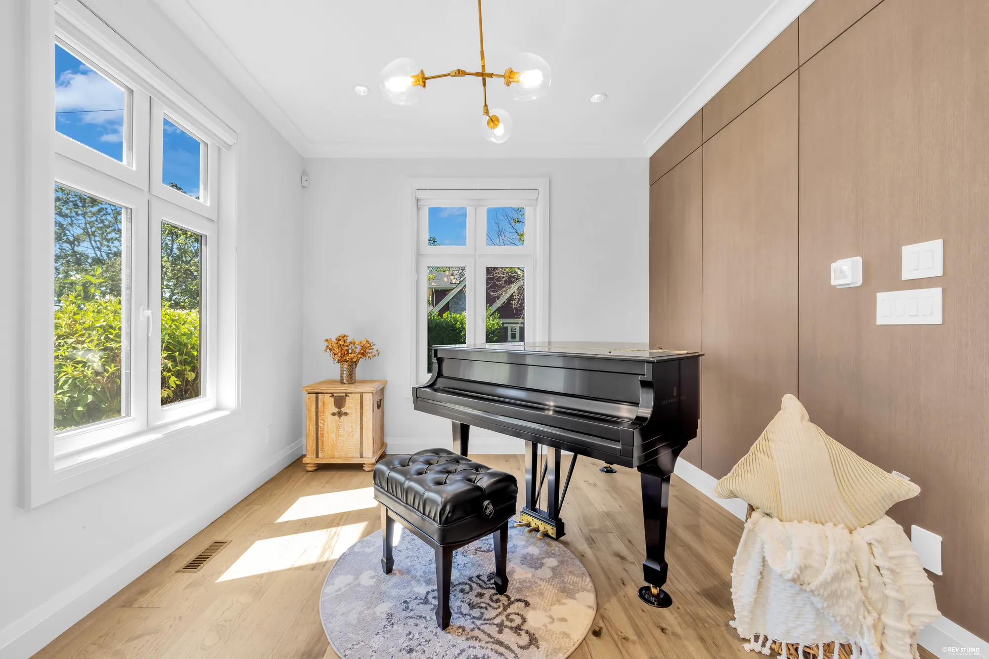 The dining room at the front-west corner, windows on two walls, currently holding a grand piano
