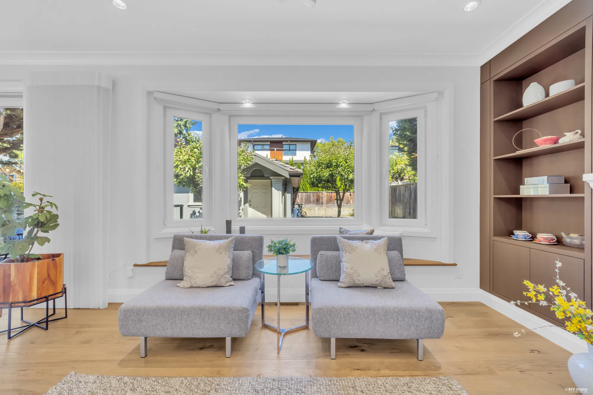 The bay window in the family room with a window seat and shelving beside it