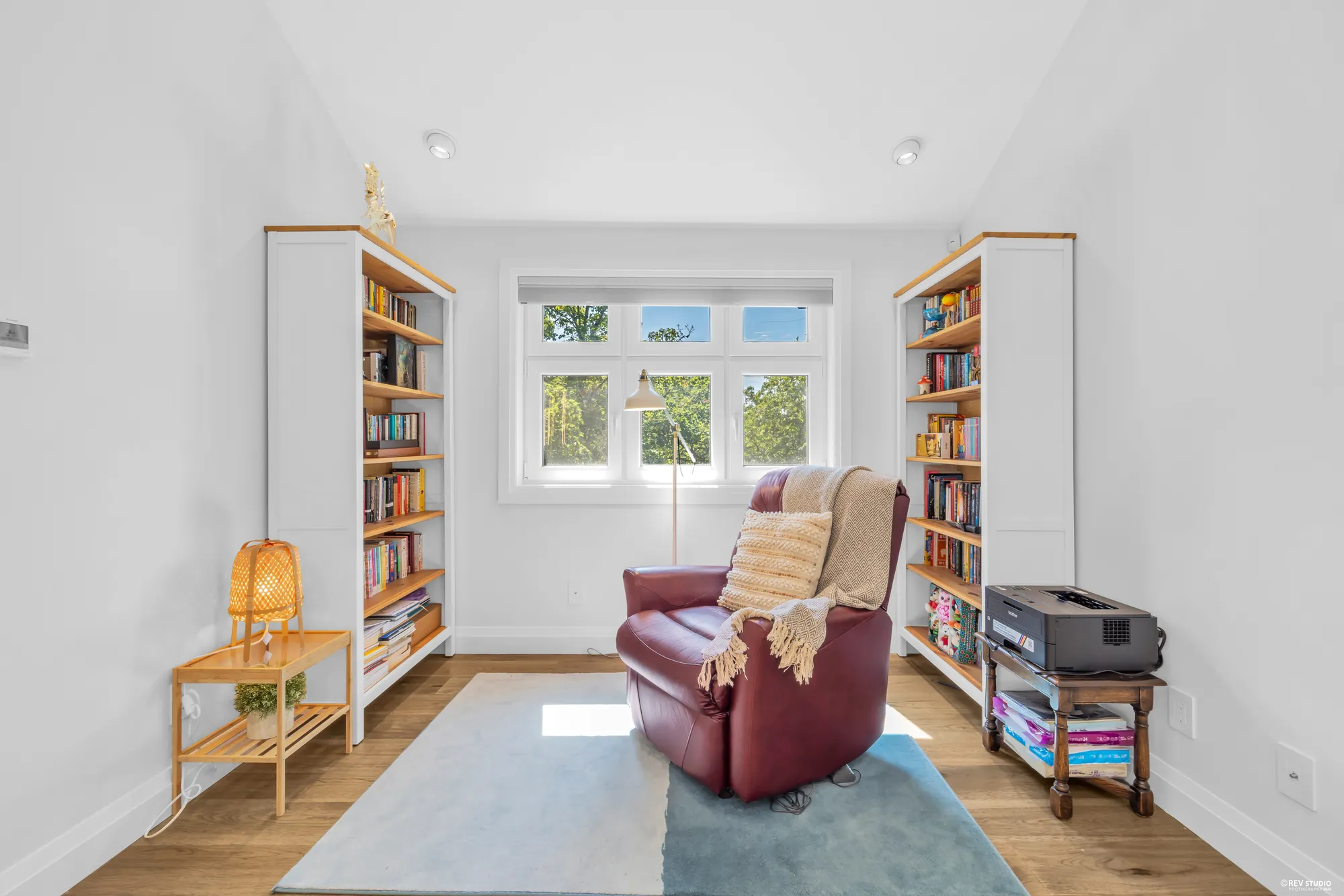The loft with built-in bookshelves either side of a window and an armchair