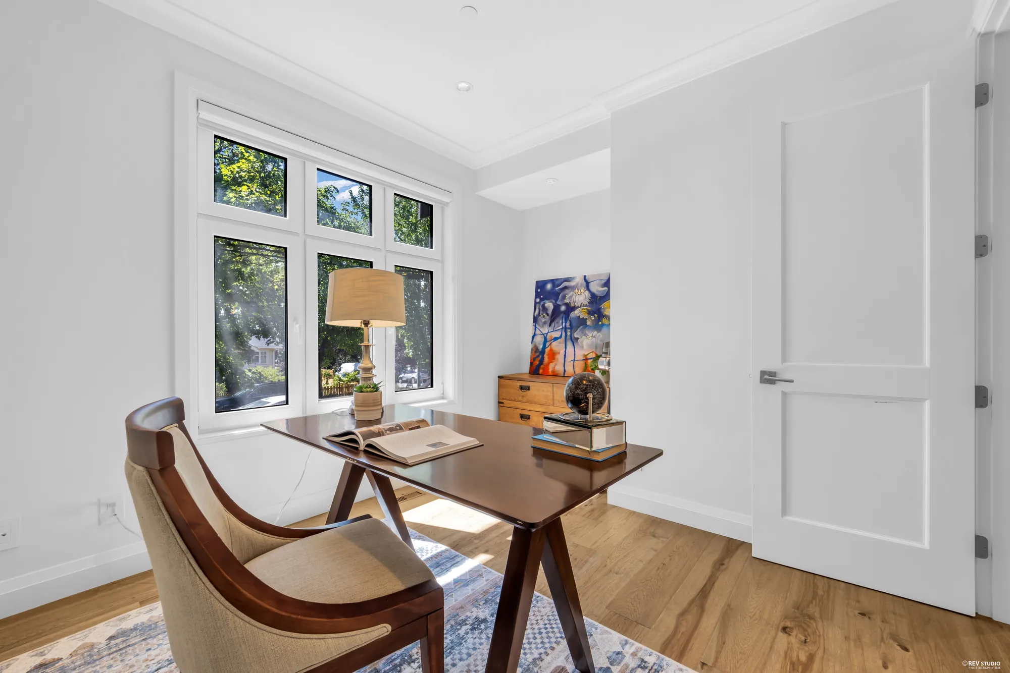 The office off the foyer, a desk under two windows