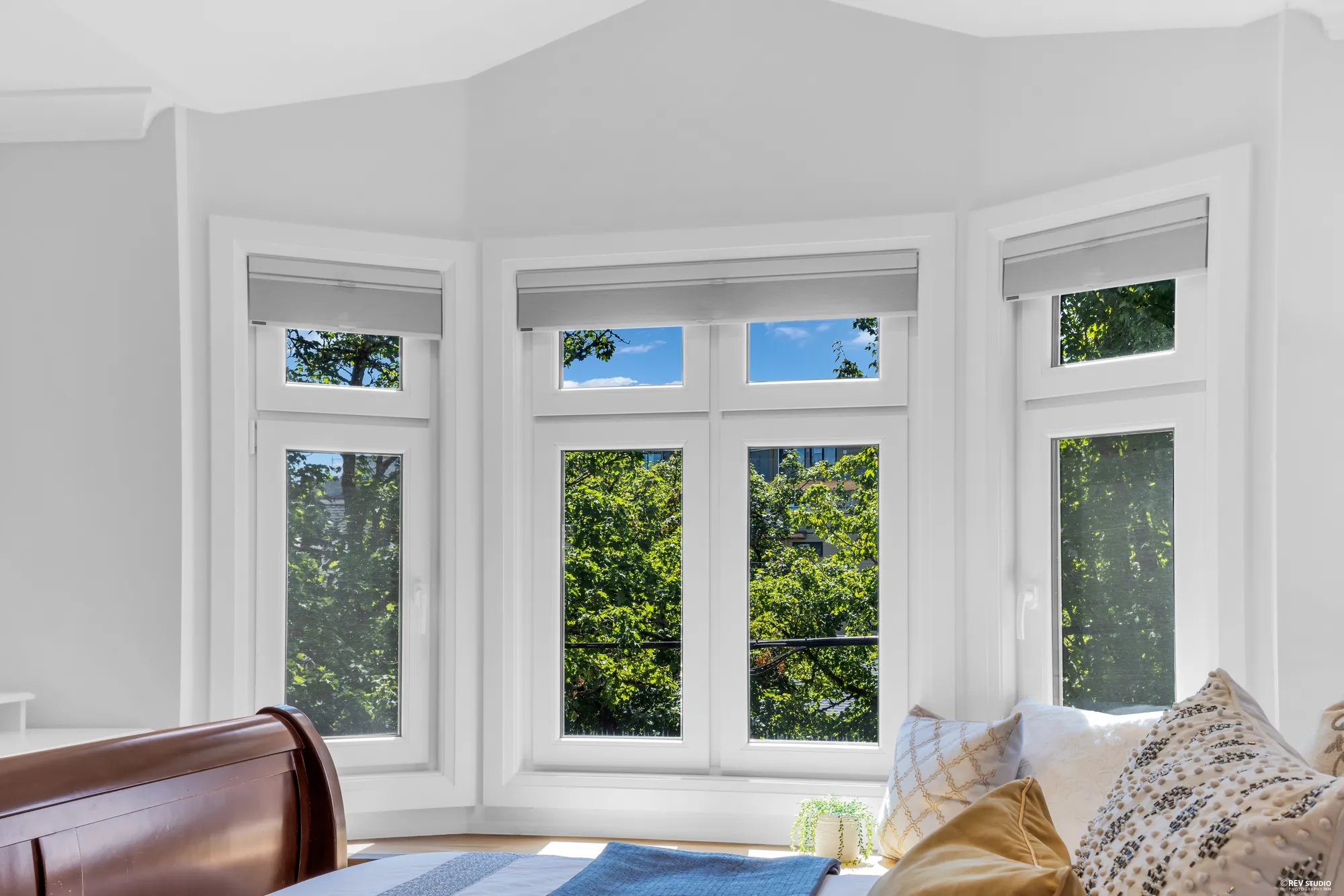 The bay window at the end of the primary bedroom, three tall windows with a seat