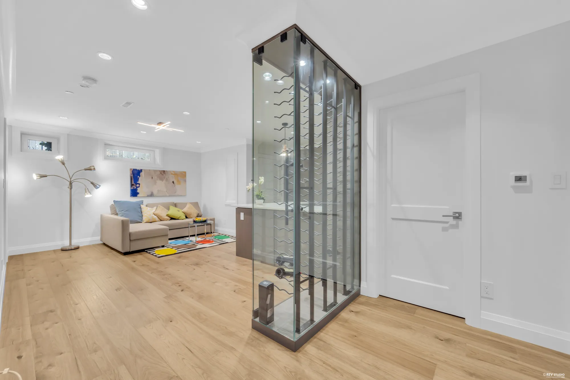 The recreation room with a full-height glass wine store standing in the middle of the floor